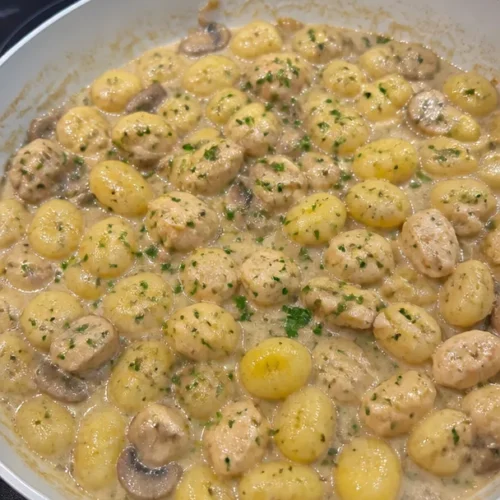 Gnocchi mit Pilz-Putenbrust-Sauce auf einem Teller serviert.