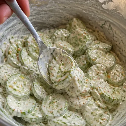 Paprika-Gurken-Salat mit Joghurt-Senf-Dressing auf einem Teller